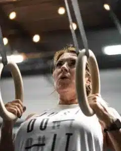 woman working out using gymnastics rings in a gym