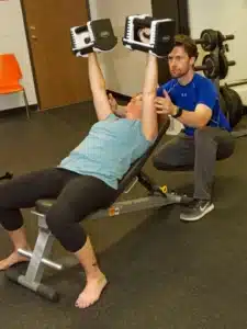 personal trainer helping a client with his service of fitness training
